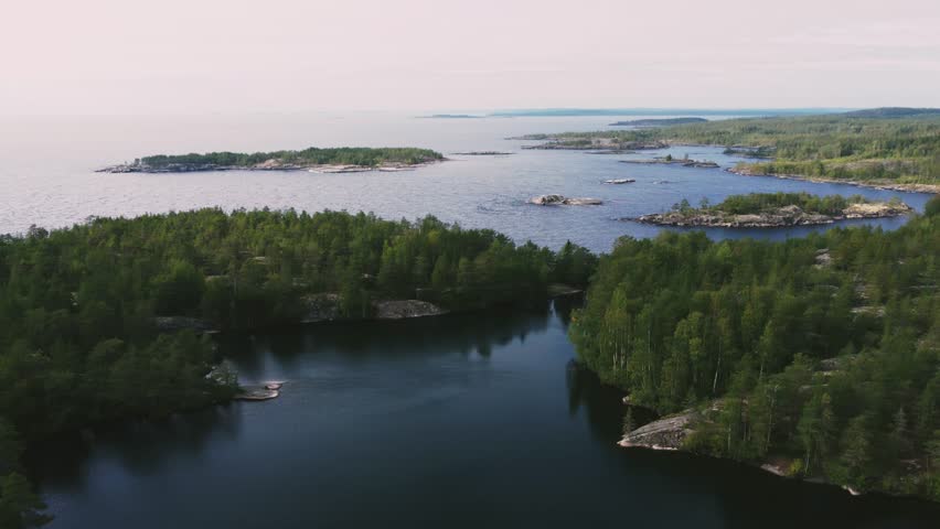 Russia, Lake Ladoga, Koyonsaari. View of the coast of the island in a cold lake. Beautiful nature of the Republic of Karelia. Panoramic view from the height of the Ladoga skerry islands. 4K