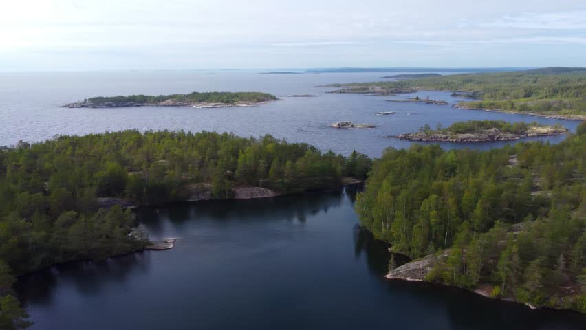 Russia, Lake Ladoga, Koyonsaari. View of the coast of the island in a cold lake. Beautiful nature of the Republic of Karelia. Panoramic view from the height of the Ladoga skerry islands. 4K