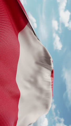 Wavy flag of Peru blowing in the wind in slow motion. Waving official Peruvian flag team symbol abstract vertical background. Blue sky with clouds. World countries flying flags concept