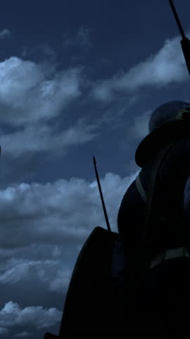 A mysterious figure stands silhouetted dramatically against the backdrop of dark, ominous clouds