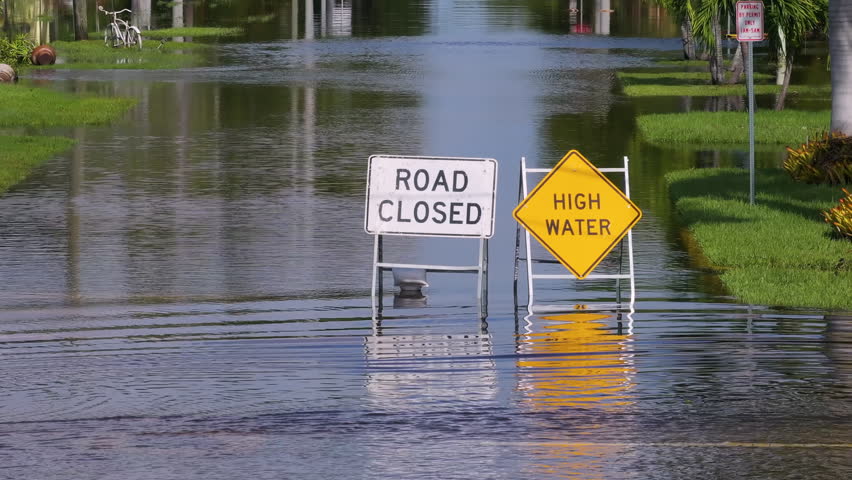 Hurricane Milton in Florida. Road under water warning sign. City street closed because of flooding danger blocking driving of cars