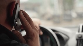 Man holds phone to his ear, and with his other hand he steers, navigating in busy traffic. Scene captures risks of inattentive driving in urban environment. Driver driving car close-up. - Powered by Shutterstock - Get 15% off with code: PIKWIZARD15