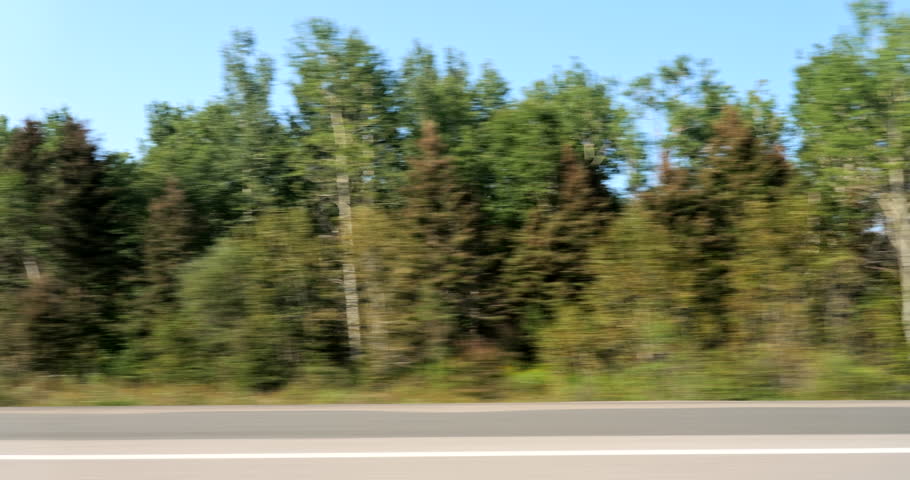 Driving plate side view on a highway through open plains and farmland in Midwestern United States agricultural fields under a wide sky rural travel and American heartland concept