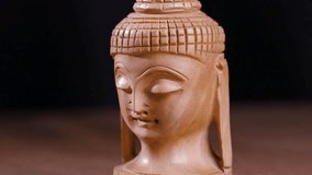 Small wooden Buddha statue figurine on a rotating turntable for meditation decor - Powered by Shutterstock - Get 15% off with code: PIKWIZARD15