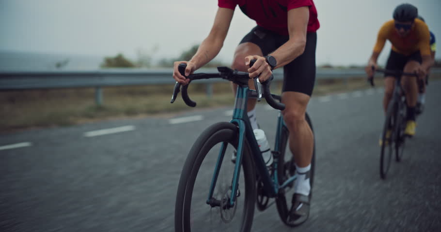 Diverse Cycling Team Races Intensely on an Open Road, Showcasing Endurance and Teamwork. Cyclists, Wearing Helmets and Colorful Jerseys, Pedal in Unison, Practicing for a Road Cycling Competition