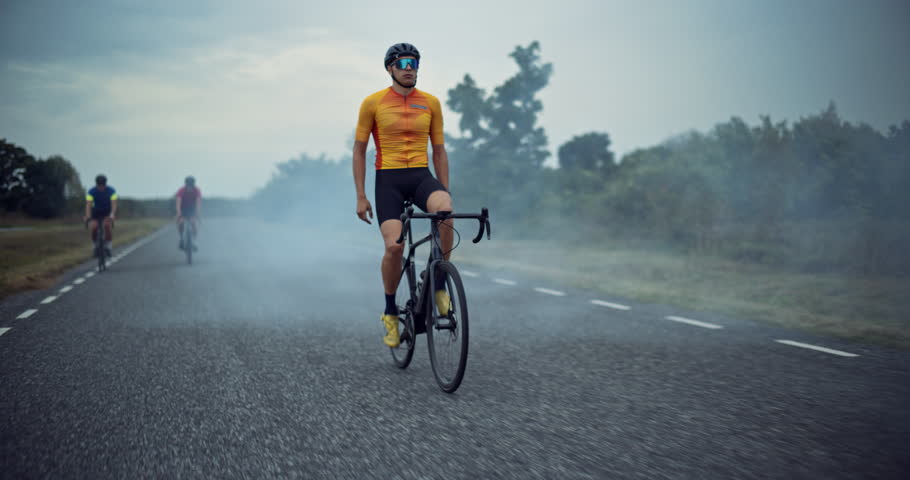 Cyclist Raises His Arms in Triumph While Crossing the Finish in Front of Competition, Celebrating a Hard-Earned Victory After an Intense Ride. His Face Lights Up with Accomplishment as He Rides