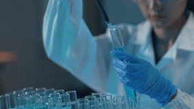 Scientist in a lab coat and safety glasses uses a pipette to drop liquid onto a petri dish for research purposes - Powered by Shutterstock - Get 15% off with code: PIKWIZARD15