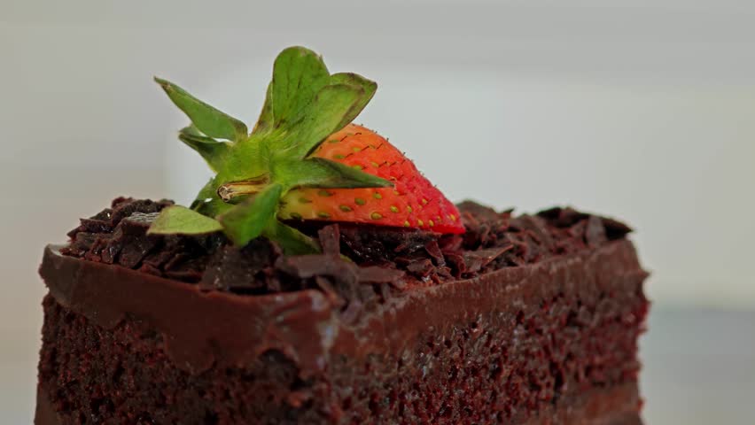 Chocolate cake with fresh strawberry, close up shot. Rotate.