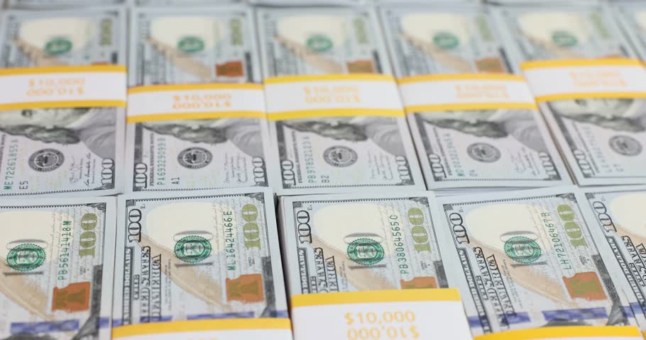 Bitcoin gold coins on a stack of hundred dollar bills. Trading and mining on cryptocurrency