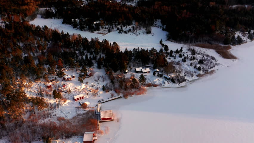 Aerial view of village on the east coast of Sweden during winter. Frozen sea and snow covered landscape.