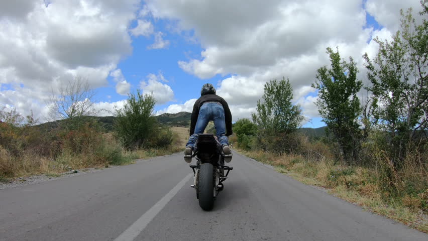 Motorcycle stunt riding fast on curvature mountain road