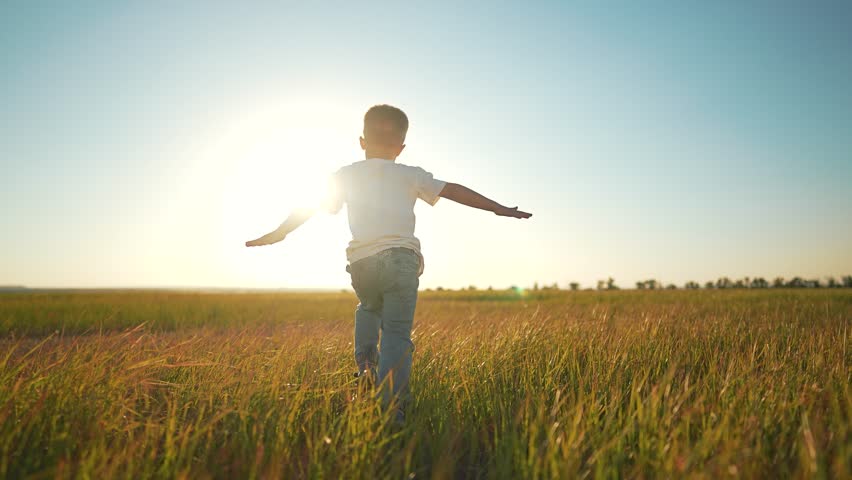 Child running outdoors enjoying freedom. Happy child plays in nature arms freedom. Joyful outdoor play at sunset. Child running freely in open field. Active lifestyle and carefree play outdoors.