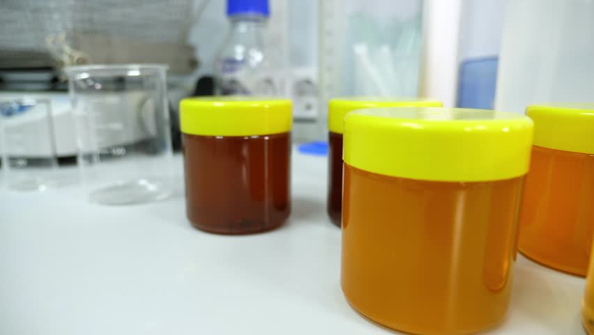 Close-up of jars of various honey in the laboratory on the table, checking honey in the laboratory for the presence of antibiotics and food additives. Production of natural honey.