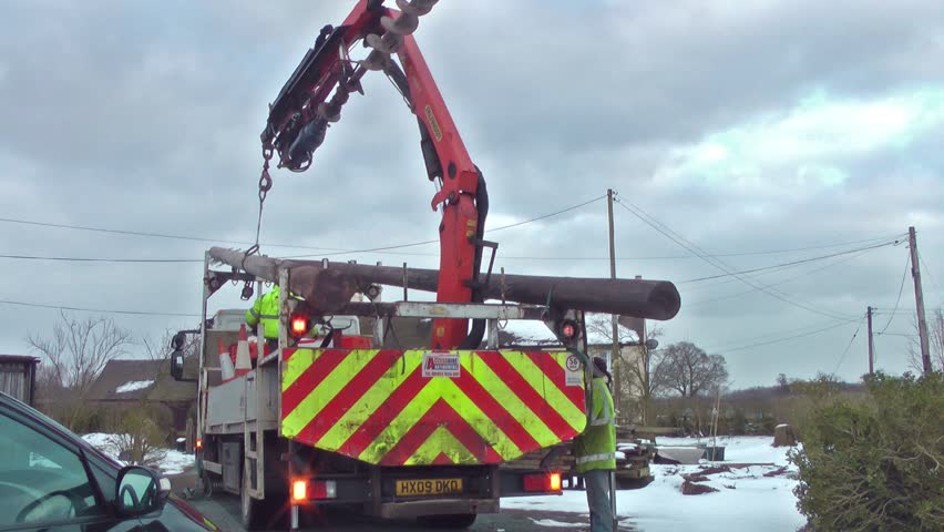 Truck Unloading Telegraph Poles