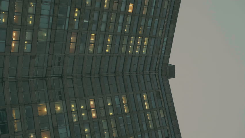 Old tall building in Moscow. Light is on in the windows of the corner house. Cloudy weather in the capital. Vertical video.