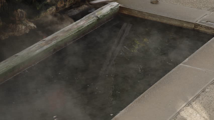 Slow video: Steam rising from the source of a hot spring