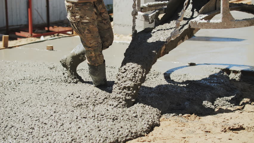 A builder pours a concrete foundation