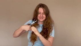 young woman with long red or light brown hair cuts off his hair and smiling at camera, concept haircut, split ends - Powered by Shutterstock - Get 15% off with code: PIKWIZARD15
