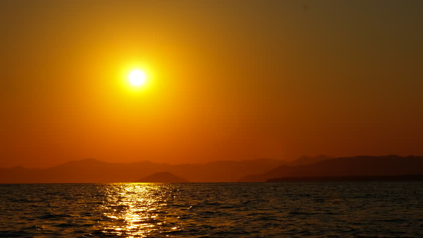 Red dusk sun over abandoned water. A view of red sun warming the water during summer evening.