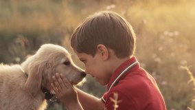 Cute little boy talking with golden retriever puppy on countryside nature background. Golden hour, sunset light. Child stroking dog. Happy lovely pet, new member of family - Powered by Shutterstock - Get 15% off with code: PIKWIZARD15