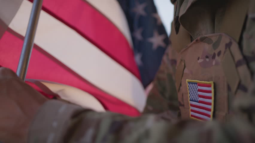 American Soldier Hoists The US Flag At The Base In The Morning