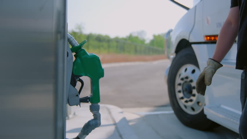The driver refuels the semi truck. Petrol station with gas pumps. Close up view