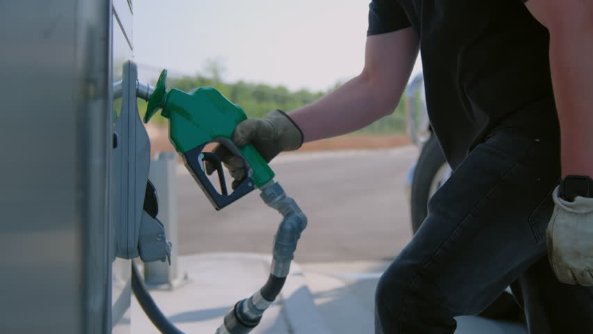 The driver refuels the semi truck. Petrol station with gas pumps. Close up view