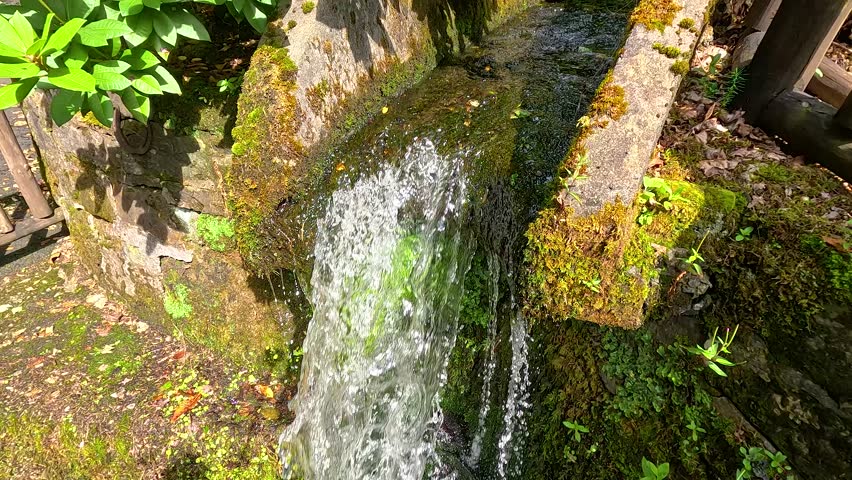 Flowing water over mossy stone structure