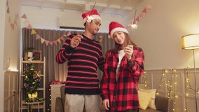 Young Asian man and beautiful Asian women playing sparkler celebration with friend,slow motion.Christmas Party concept. - Powered by Shutterstock - Get 15% off with code: PIKWIZARD15