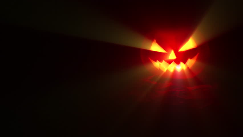 Jack-o-lantern - Halloween pumpkin with candle against a dark background with light rays, in a spooky Halloween concept, 4k