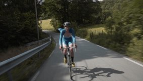 Front-Facing Follow Shot of a Road Cyclist Whizzing Down Empty Roads Amidst.. - Powered by Shutterstock - Get 15% off with code: PIKWIZARD15