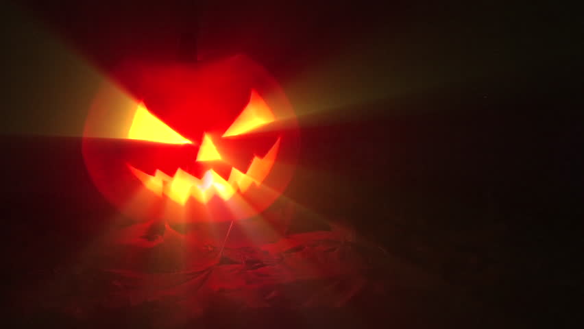 Jack-o-lantern - Halloween pumpkin with candle against a dark background with light rays, in a spooky Halloween concept, 4k
