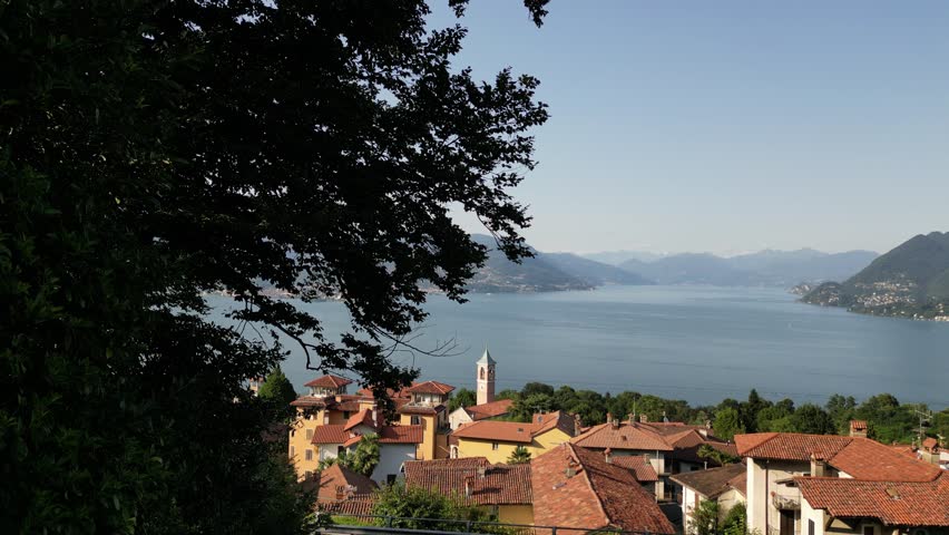 Horizontal drone above video of Italian lake Lago Maggiore with traditional red tiled roofs