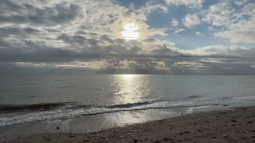 Relaxing Morning Sunbeams and Clouds over Calm Seas and Beach Shoreline
