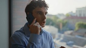 Portrait angry ceo calling cellphone at office window. Nervous businessman quarrelling in smartphone worried business problems indoors. Furious man boss yelling in mobile phone talk feeling stress. - Powered by Shutterstock - Get 15% off with code: PIKWIZARD15