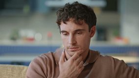 Thoughtful guy drinking coffee sitting sofa at relaxed home environment closeup. Relaxed man thinking at future with calm demeanor. Handsome male lost in deep thought at peaceful morning in apartment. - Powered by Shutterstock - Get 15% off with code: PIKWIZARD15