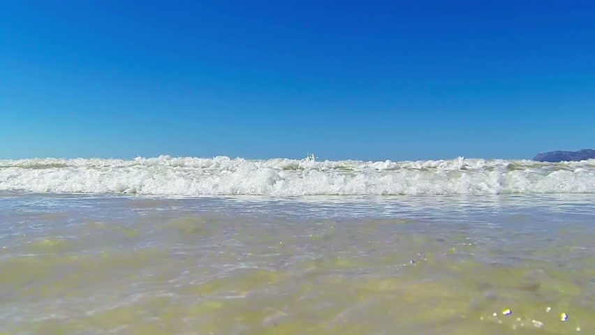 Small ocean wave hitting camera
