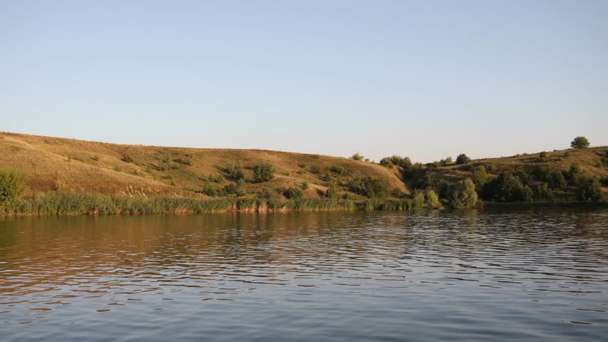 a lake near a glade and hills in the summer, a beautiful landscape