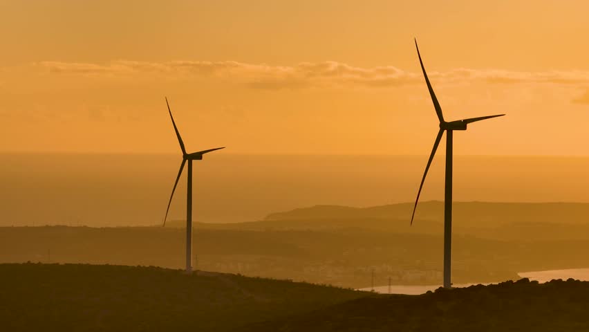 A powerful image representing the commitment to a greener future through wind energy. The windmill stands tall against a clear sky, its blades turning steadily, harnessing clean, renewable energy. 