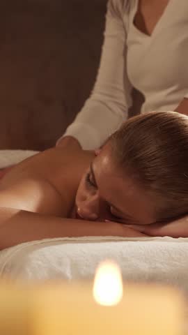 Woman is getting massage treatment from the therapist. Massaging procedure in spa. Healthcare, relaxation, rejuvenation and wellness concept.