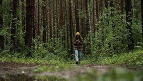 Young woman walking along a forest path uses her smartphone. Dressed in casual clothing and a beanie, she enjoys the beauty of nature while staying connected - Powered by Shutterstock - Get 15% off with code: PIKWIZARD15