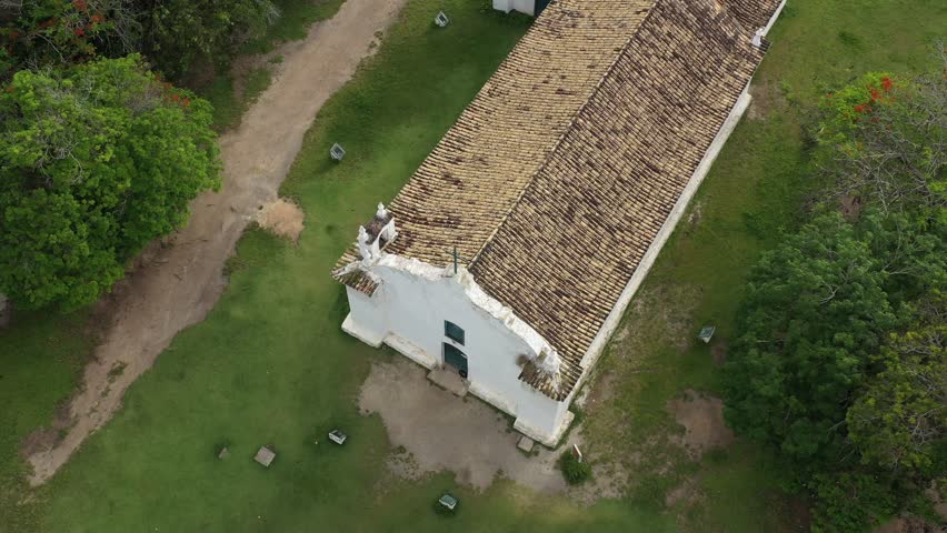 Aerial view of a rustic church in Trancoso, Bahia, surrounded by greenery and paths