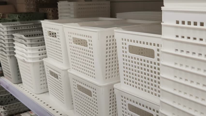 Man chooses plastic container at hardware store. Customer holding small plastic box for different kind of fasteners. White box for nails, bolts and screws. Small basket for different things at home