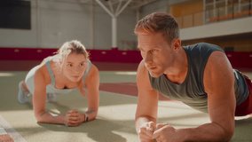 Athletic woman and man perform plank exercises together in sports club. Couple rests breathing deeply improving endurance at intensive workout without equipment - Powered by Shutterstock - Get 15% off with code: PIKWIZARD15
