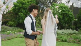 Animation of cloud house over happy diverse couple walking in garden on wedding day. Couple, marriage, nature, summer, celebration, future, togetherness, love and romance, digitally generated video. - Powered by Shutterstock - Get 15% off with code: PIKWIZARD15