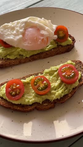 Breakfast of poached eggs on bread with avocado and cherry tomatoes. Healthy breakfast.