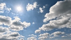 Beautiful Endless Clouds in the Daylight Skies. 4K video (Ultra High Definition) of cloudscape and bright sun. Sky and clouds Timelapse. Ssun shines through the clouds on the blue sky background. - Powered by Shutterstock - Get 15% off with code: PIKWIZARD15