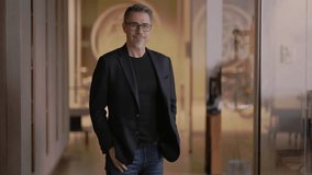 Business portrait - businessman standing on office corridor. Happy middle aged, mid adult, mature age man smiling. Entrepreneur in modern workplace. Copy space. - Powered by Shutterstock - Get 15% off with code: PIKWIZARD15