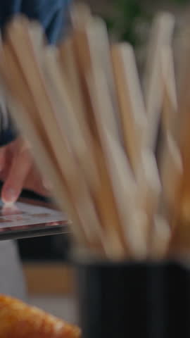 Operator looking at modern touch tablet in kitchen in coffee shop. Concept of bartender serving customers showing his coffee making skills