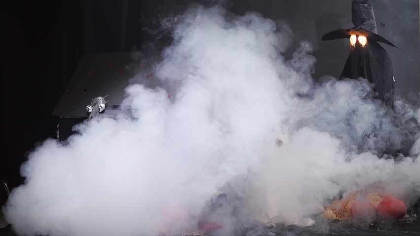 Border Collies dressed as ghosts appear through fog in a spooky Halloween setting with a haunted house and pumpkins. The scene is both eerie and playful.